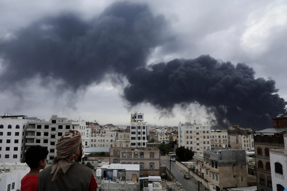 Yemenis watch as smoke billows following Israeli airstrikes targeting a power plant and Sanaa Airport, in Sanaa, Yemen, Tuesday, May 6, 2025. (AP Photo/Osamah Abdulrahman)