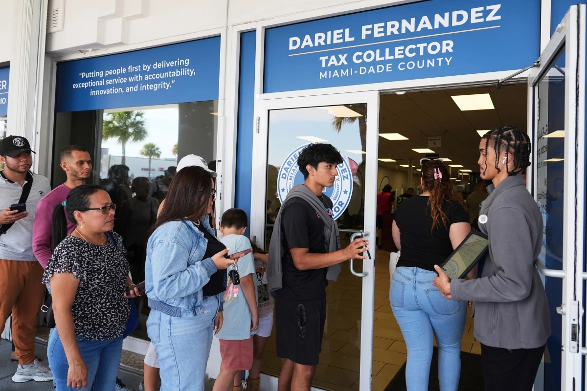 Customer Service representative Marlon Suarez, right, monitors the doorway outside of a Miami-Dade County Office of the Tax Collector Tuesday, May 6, 2025, in Miami. (AP Photo/Lynne Sladky)