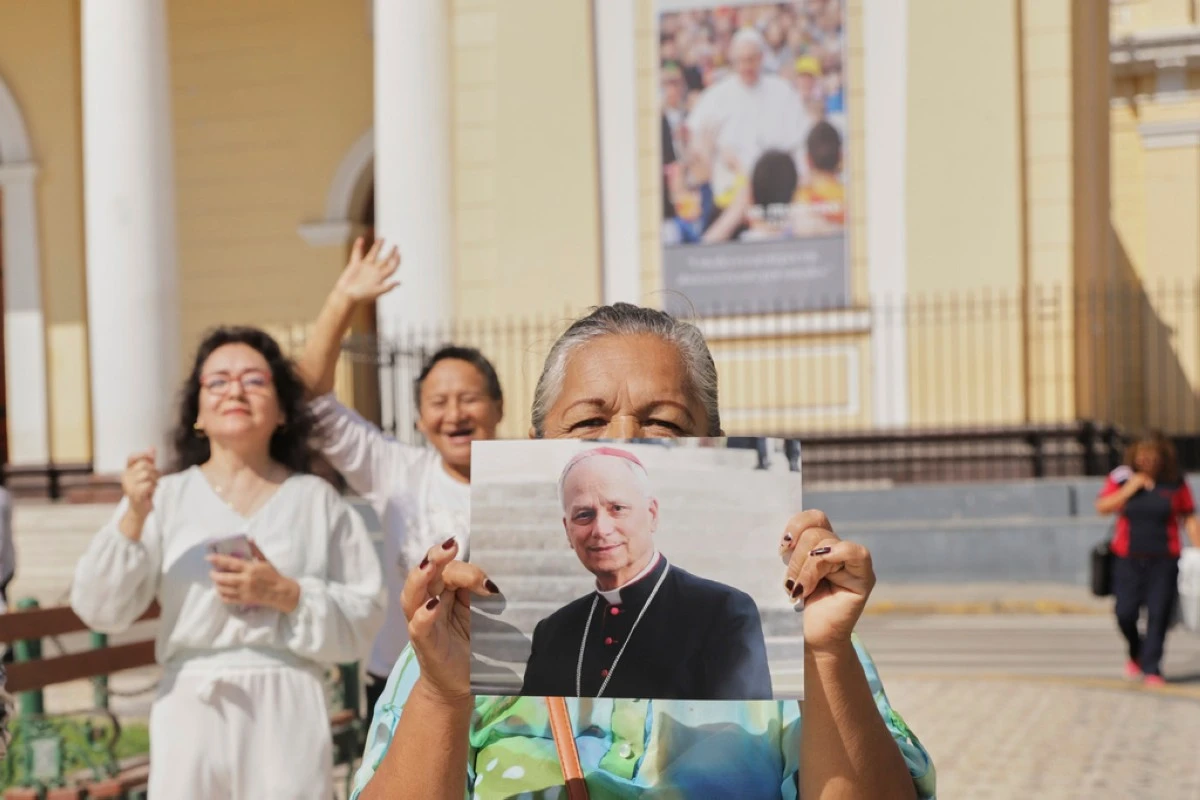 Faithful hold a photo of Bishop Robert Prevost, who was elected Pope Leo XIV, in front of the Cathedral of Chiclayo, Peru, Thursday, May 8, 2025, where he served as bishop for several years, (AP Photo/Manuel Medina)