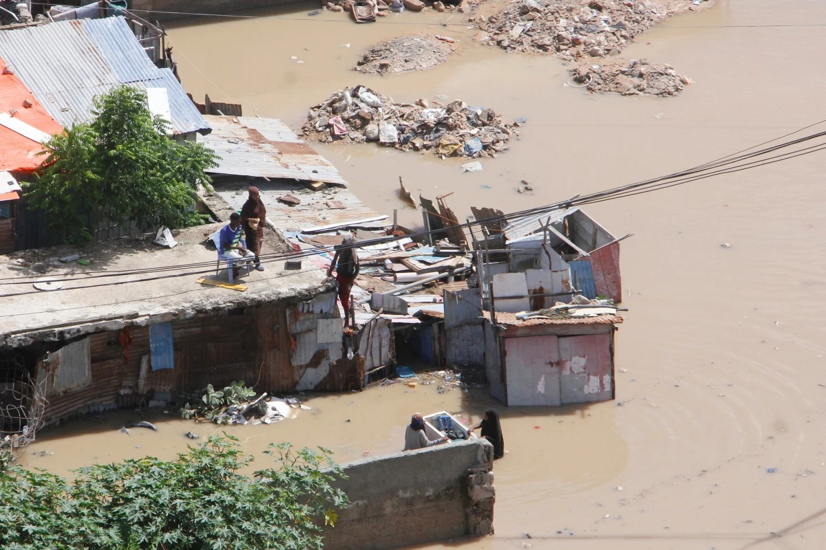 People stand on top of a flooded building following a heavy downpour, in Mogadishu, Somalia, Saturday, May 10, 2025. (AP Photo/Farah Abdi Warsameh)