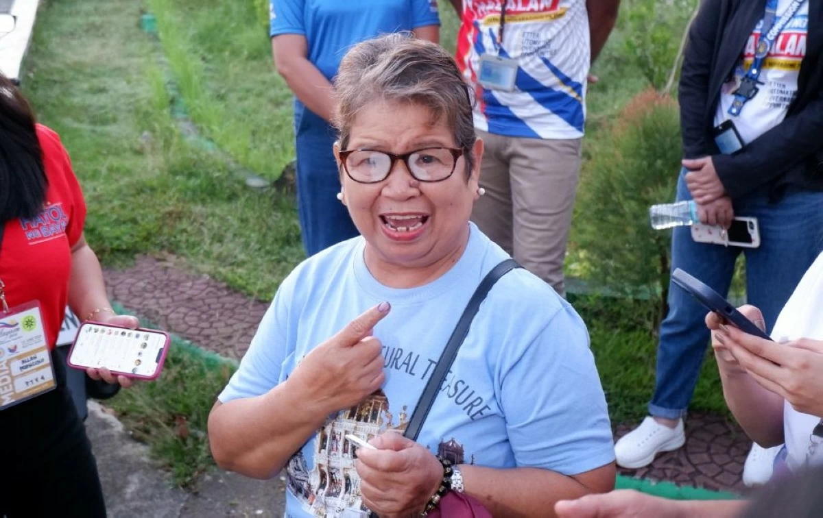 Senior citizen and early voter Zenaida Chew shows her ink-stained finger after casting her vote in Silang Central Elementary School on May 12 (Carla Bauto Deña/MANILA BULLETIN)