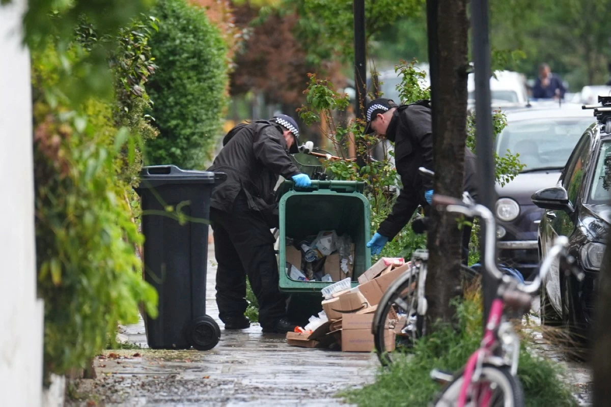 Police officers search a bin in Kentish Town, near British Prime Minister Keir Starmer's house in north London, Monday, May 12, 2025. (James Manning/PA via AP)