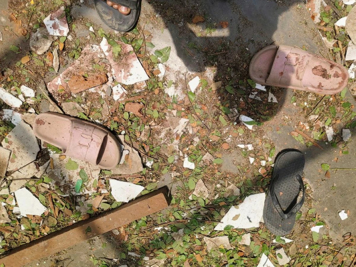 Footwear lie with scattered with debris on the ground of a high school after it was allegedly hit by a military airstrike in Ohe Htein Twin village in Tabayin township, also known as Depayin in Sagaing region, Myanmar, May12, 2025. (White Depeyin People Defence Force via AP)