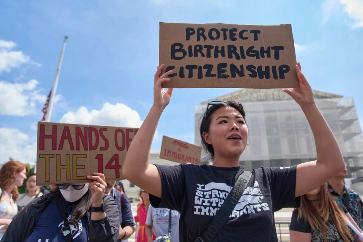 Hannah Liu, 26, of Washington, holds up a sign in support of birthright citizenship, Thursday, May 15, 2025, outside of the Supreme Court in Washington. 