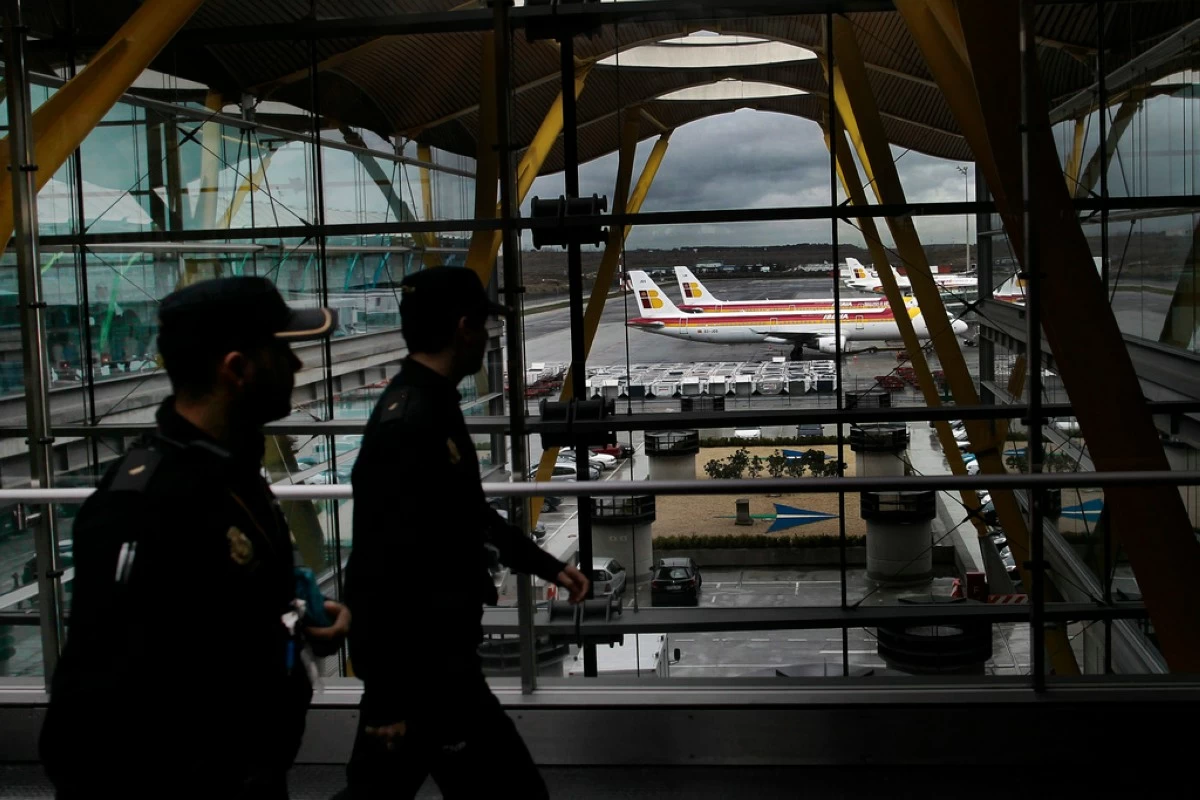 FILE - Iberia jets are seen in a parking zone as police walk through the airport during a Iberia airline workers strike at Barajas international airport in Madrid, Spain, Tuesday, March 5, 2013.  (AP Photo/Andres Kudacki, File)