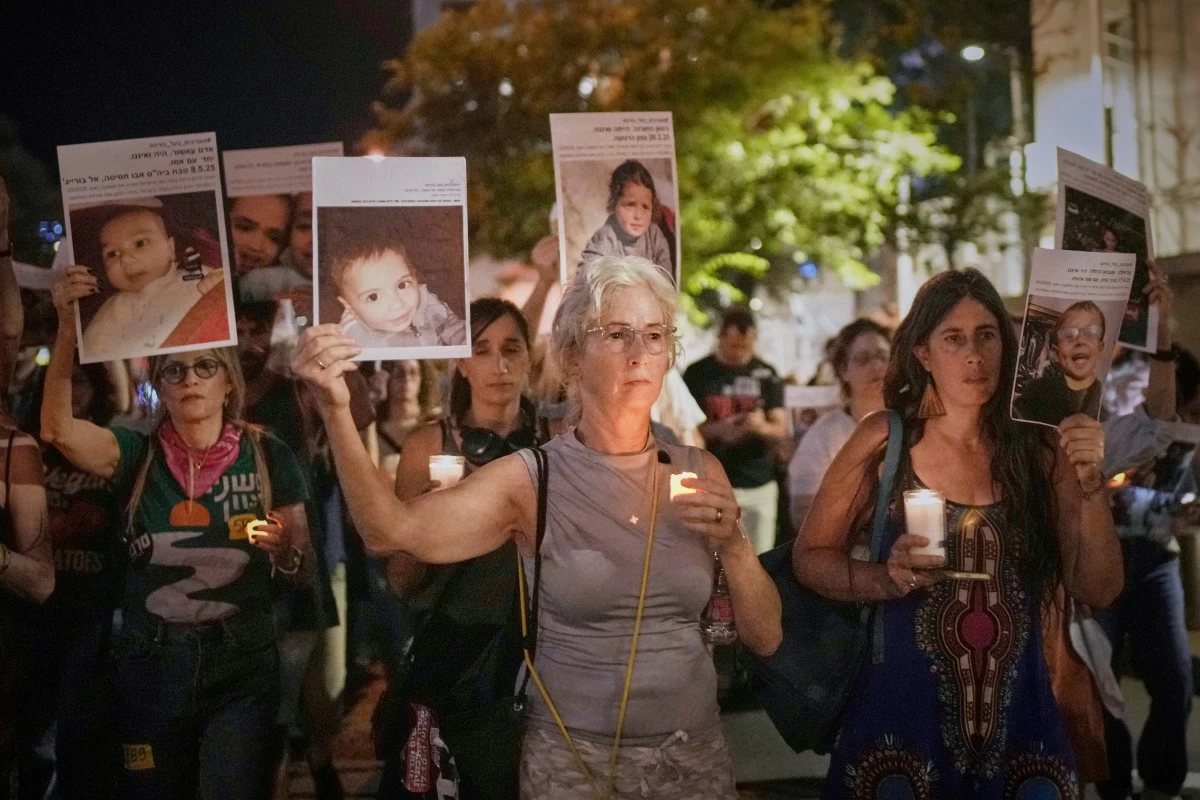 Protesters hold pictures of Palestinian children killed during Israel's military operation in the Gaza Strip in a protest demanding the end of the war, in Tel Aviv, Israel, Saturday, May 17, 2025. (AP Photo/Maya Alleruzzo)