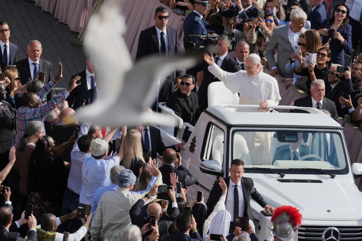 A bird flies by as Pope Leo XIV on his popemobile tours St. Peter's Square at the Vatican prior to the inaugural Mass of his pontifcate, Sunday, May 18, 2025. (AP Photo/Jacquelyn Martin, Pool)