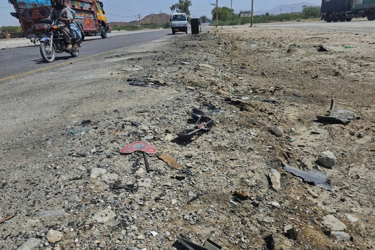 A motorcyclist and vehicles drive past the site of suicide bombing at a highway on the outskirts of the city of Khuzdar, in southwestern Pakistan, Wednesday, May 21, 2025. (AP Photo)