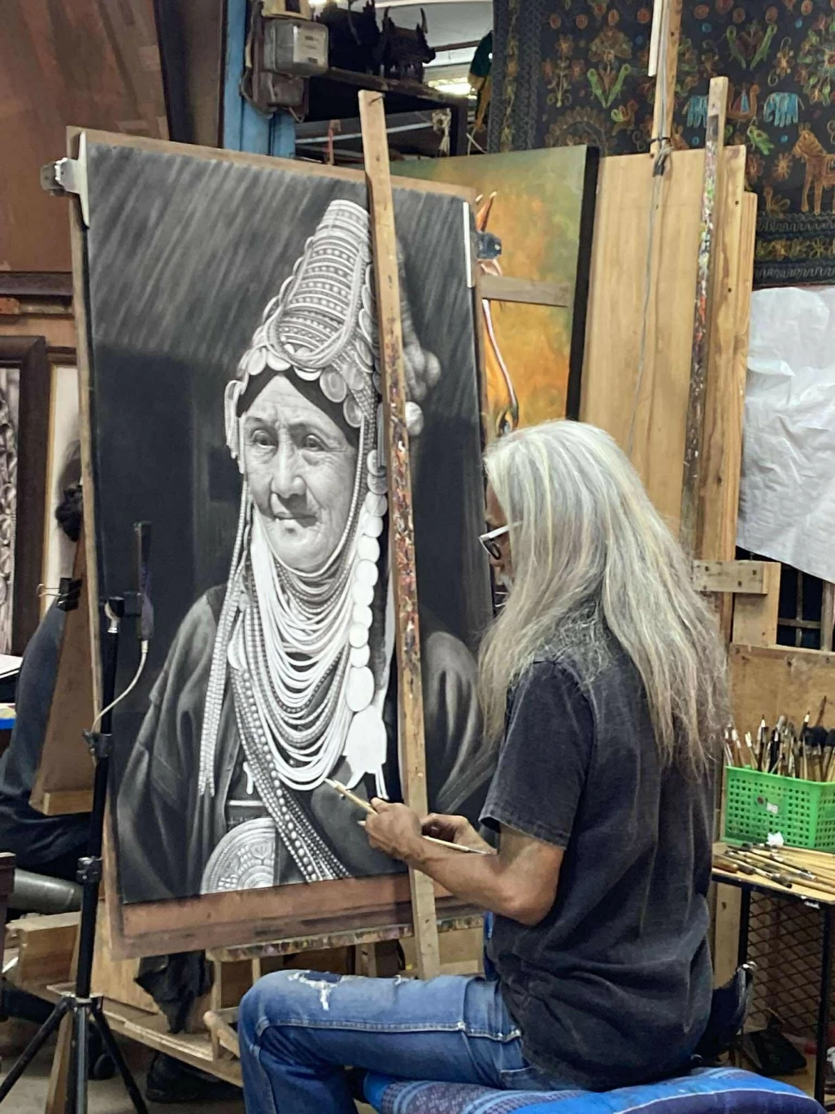 ARTIST AT WORK One of the art store owners at the Anusarn Night Market shows off his painting skills.