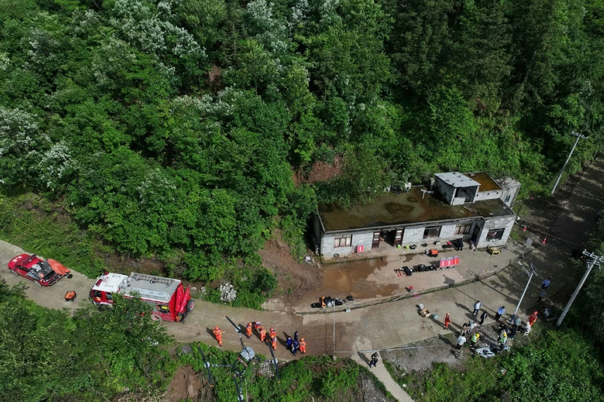 In this photo released by Xinhua News Agency, rescuers prepare to conduct a search and rescue operation following a landslides in Qingyang Village of Guowa township in southwest China's Guizhou Province, Thursday, May 22, 2025. (Yang Wenbin/Xinhua via AP)