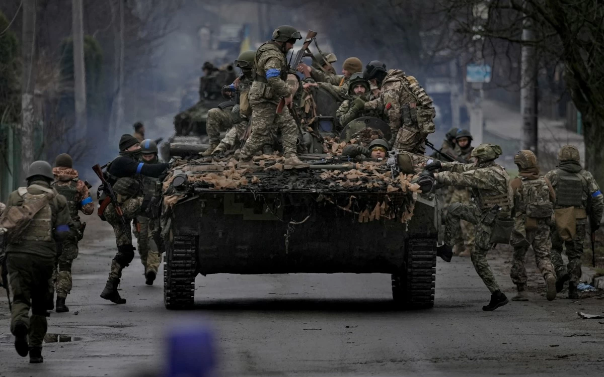 FILE - Ukrainian servicemen climb on a vehicle outside Kyiv, Ukraine, on April 2, 2022. (AP Photo/Vadim Ghirda, File)