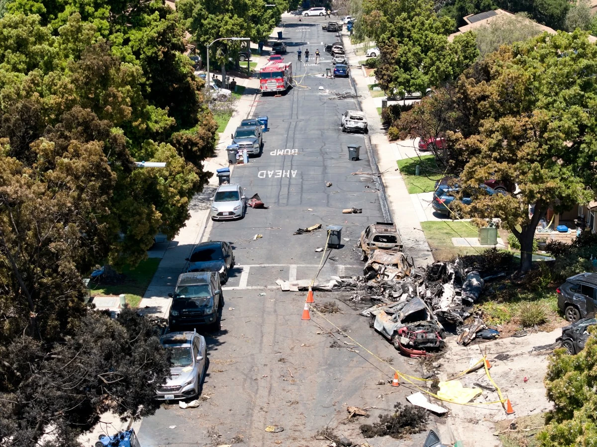 Debris covers the ground after a small plane crashed into a San Diego neighborhood, setting homes and cars on fire and forcing evacuations early Thursday, May 22, 2025. (AP Photo/William Liang)