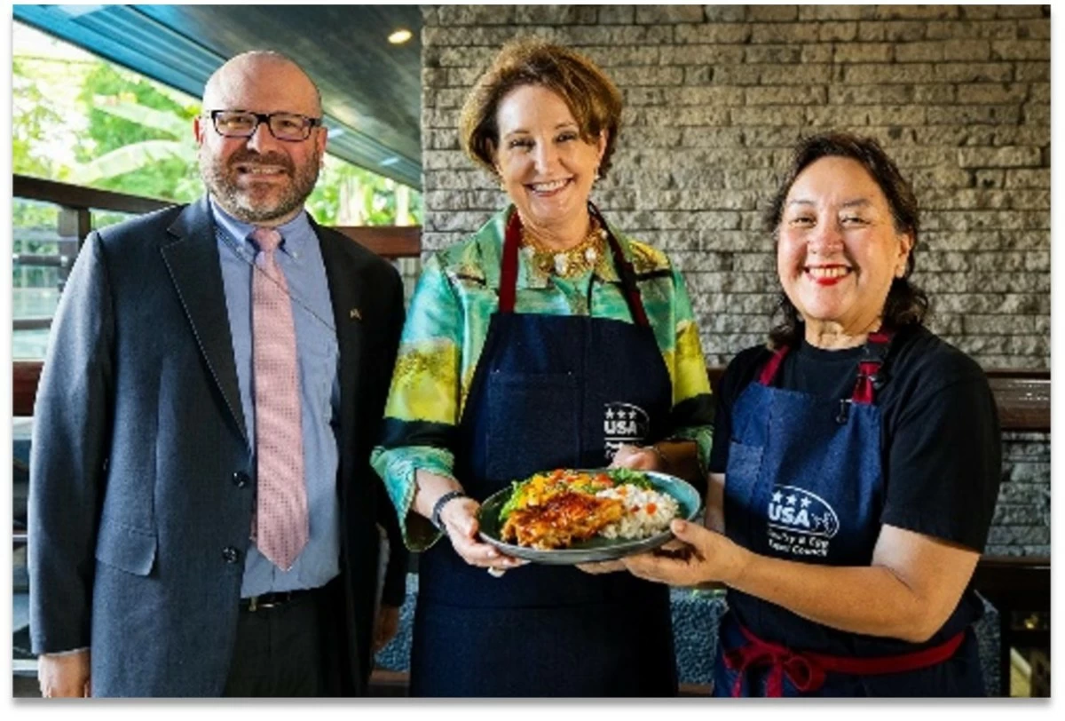 US Embassy Agricultural Counselor Michael Ward, Ambassador MaryKay Carlson of the US Embassy, and Chef Nancy Reyes-Lumen hold a plate of Chicken BBQ Adobo.
