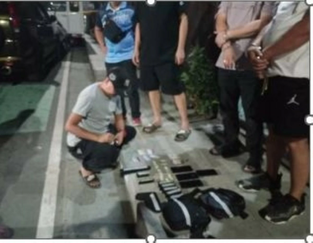Metro Manila police inspect the firearms seized from the three suspects during an operation in Makati City