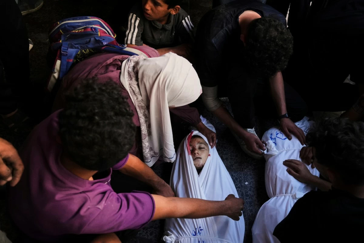 Mourners gather around the body of Palestinian child Ghazwane Hamdan,10, killed in an Israeli army airstrike, and brought to the Baptist Hospital in Gaza City, Monday, May 26, 2025. (AP Photo/Jehad Alshrafi)