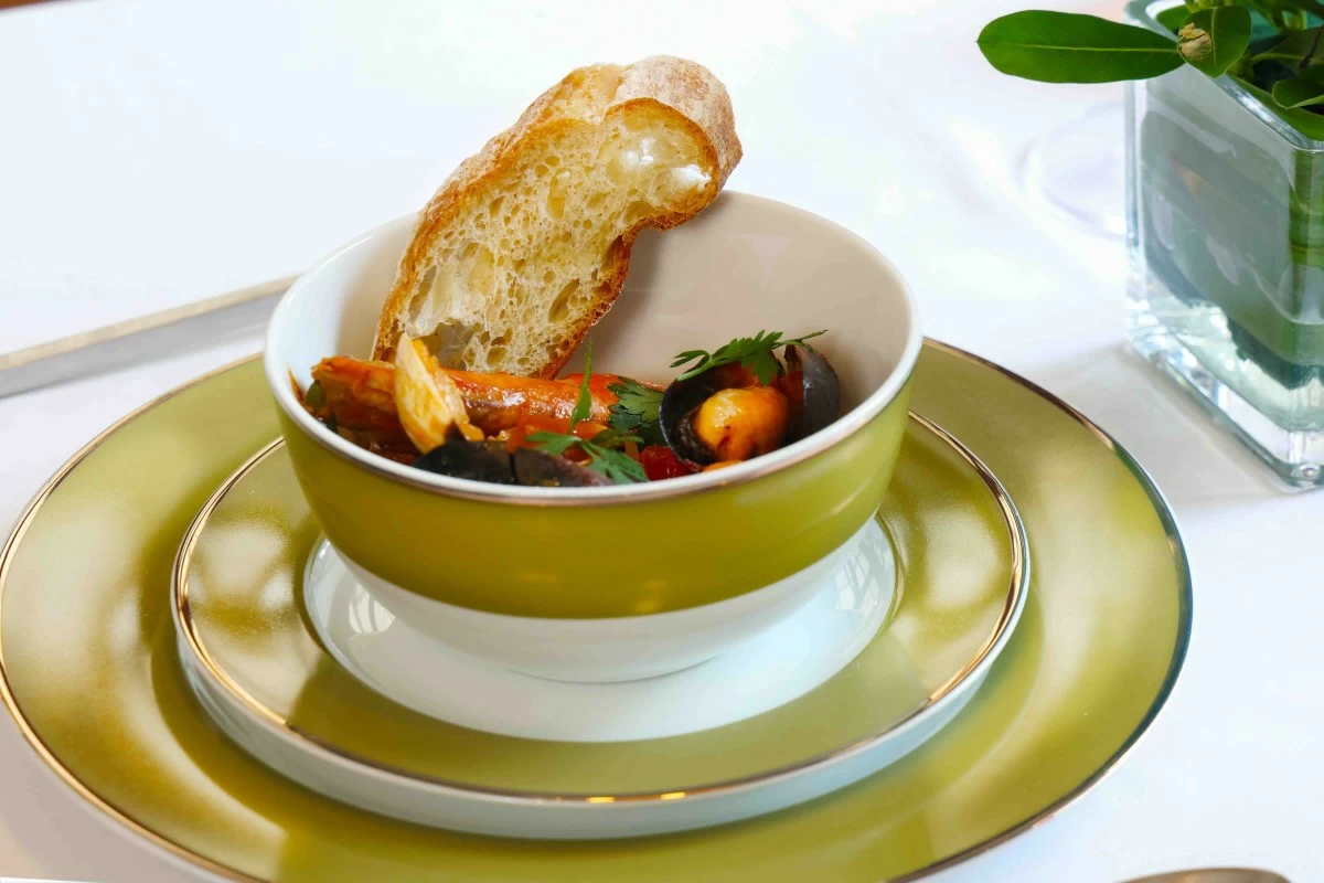 PLATED ELEGANCE A rich Mediterranean seafood stew served in the olive-toned Gracie Lane dinnerware