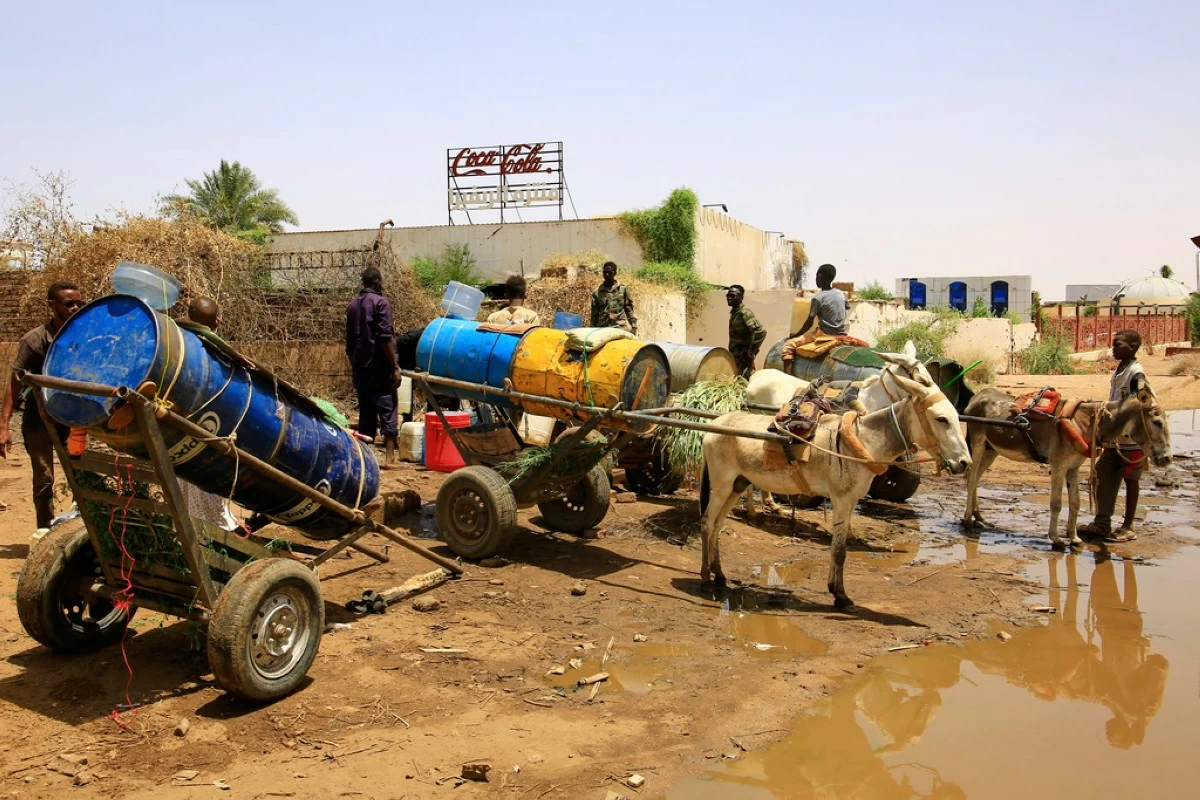 People fill water containers at a distribution point due to water outages in Khartoum, Sudan, Sunday, May 25, 2025. (AP Photo)
