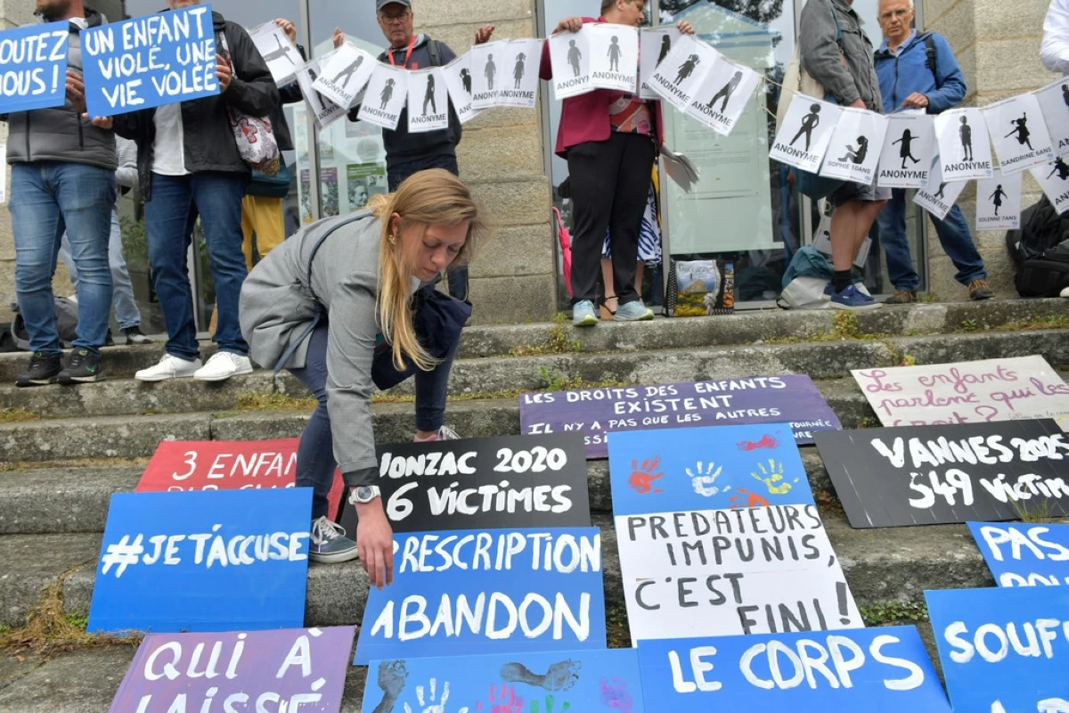 People place posters during a demonstration ahead of the verdict in the trial of Joel Le Scouarnec, a 74-year-old former surgeon, accused of raping and sexually assaulting 299 children, Wednesday, May 28, 2025 in Vannes, Brittany, western France. (AP Photo/Mathieu Pattier)