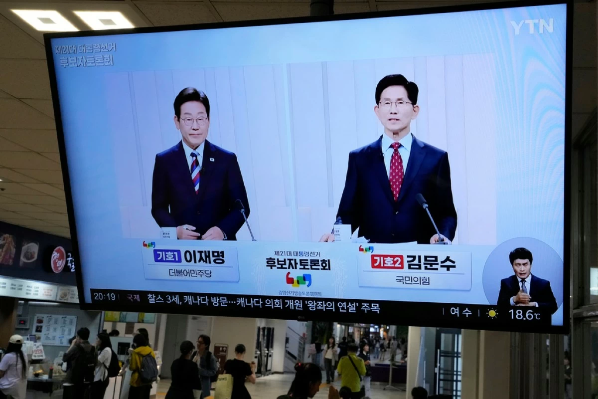FILE - A TV screen shows the People Power Party's presidential candidate Kim Moon Soo, right, and the Democratic Party's presidential candidate Lee Jae-myung during a presidential debate for the upcoming June 3 presidential election, at a bus terminal in Seoul, South Korea, on May 27, 2025. (AP Photo/Ahn Young-joon, File)