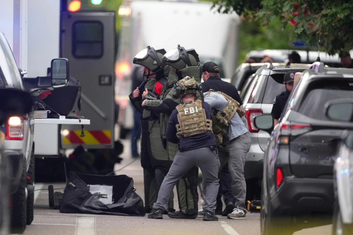 Law enforcement officials dress in protective gear to investigate after an attack on the Pearl Street Mall Sunday, June 1, 2025, in Boulder, Colo. (AP Photo/David Zalubowski)