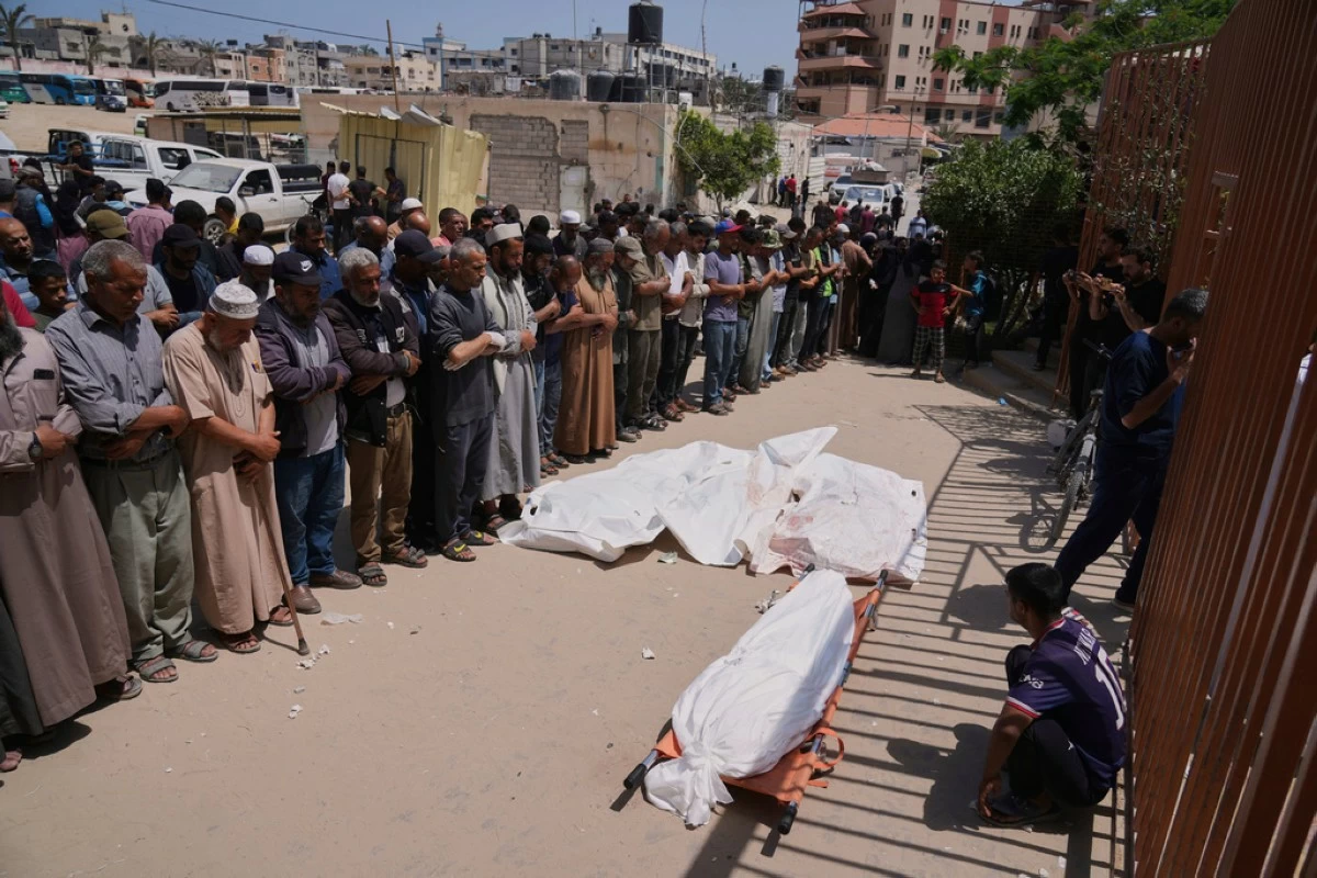Palestinians pray during the funeral of a person who was killed while heading to a Gaza aid hub, along with three others who were killed during an Israeli strike, as they gather at the Nasser Hospital in Khan Younis, southern Gaza Strip, Sunday, June 1, 2025. (AP Photo/Abdel Kareem Hana)