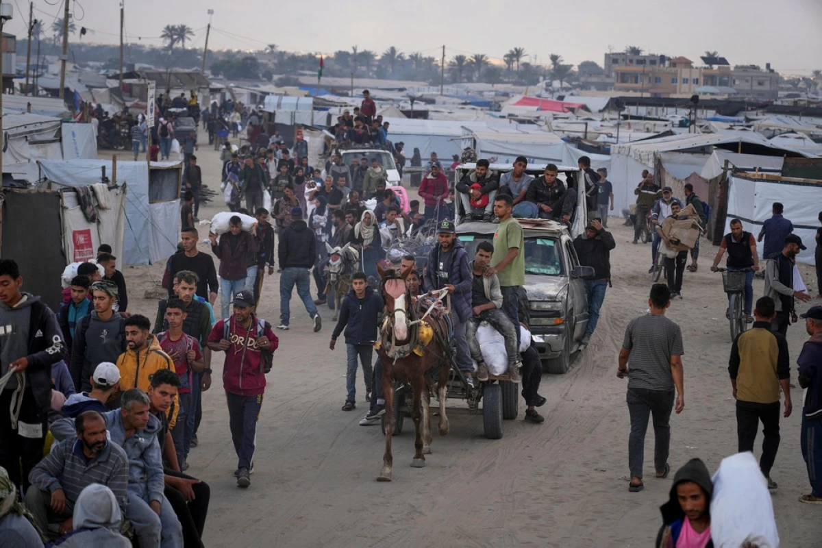 Palestinians carry bags filled with food and humanitarian aid provided by the Gaza Humanitarian Foundation, a U.S.-backed organization approved by Israel, in Khan Younis, southern Gaza Strip, on Tuesday, June 3, 2025. (AP Photo/Abdel Kareem Hana)