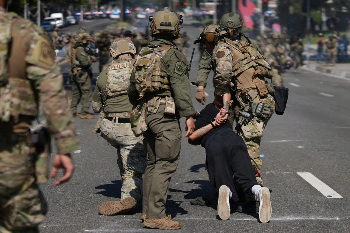 Police detain a man during a protest in Paramount, Calif., Saturday, June 7, 2025, after federal immigration authorities conducted operations. (AP Photo/Eric Thayer)