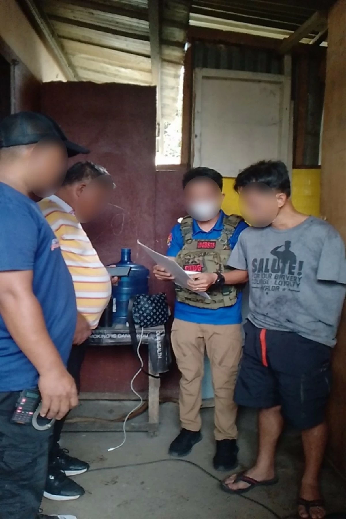 A CIDG operative serves the arrest warrant against an alleged ranking officer of the CPP-NPA in Mindanao during an operation in Cagayan de Oro City on June 5, 2025. (photo: CIDG) 