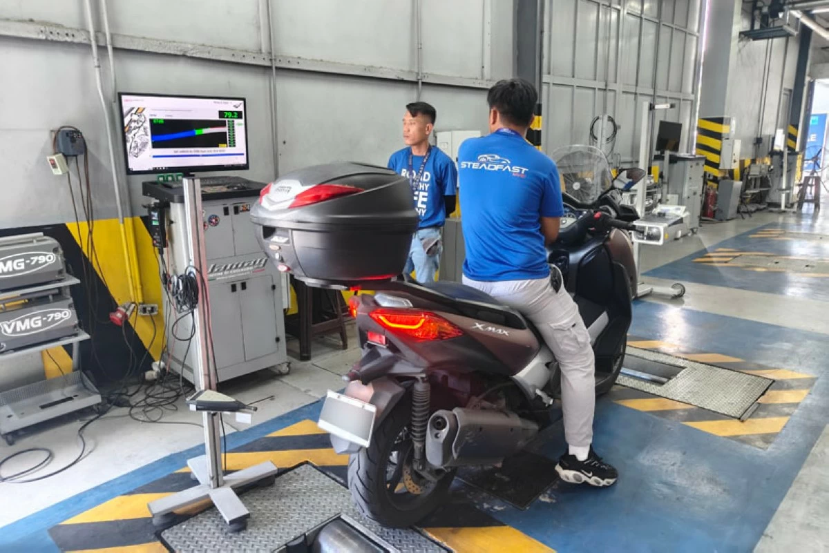 A motorcycle's exhaust note is tested with a decibel meter to ensure it meets the regulated volume.