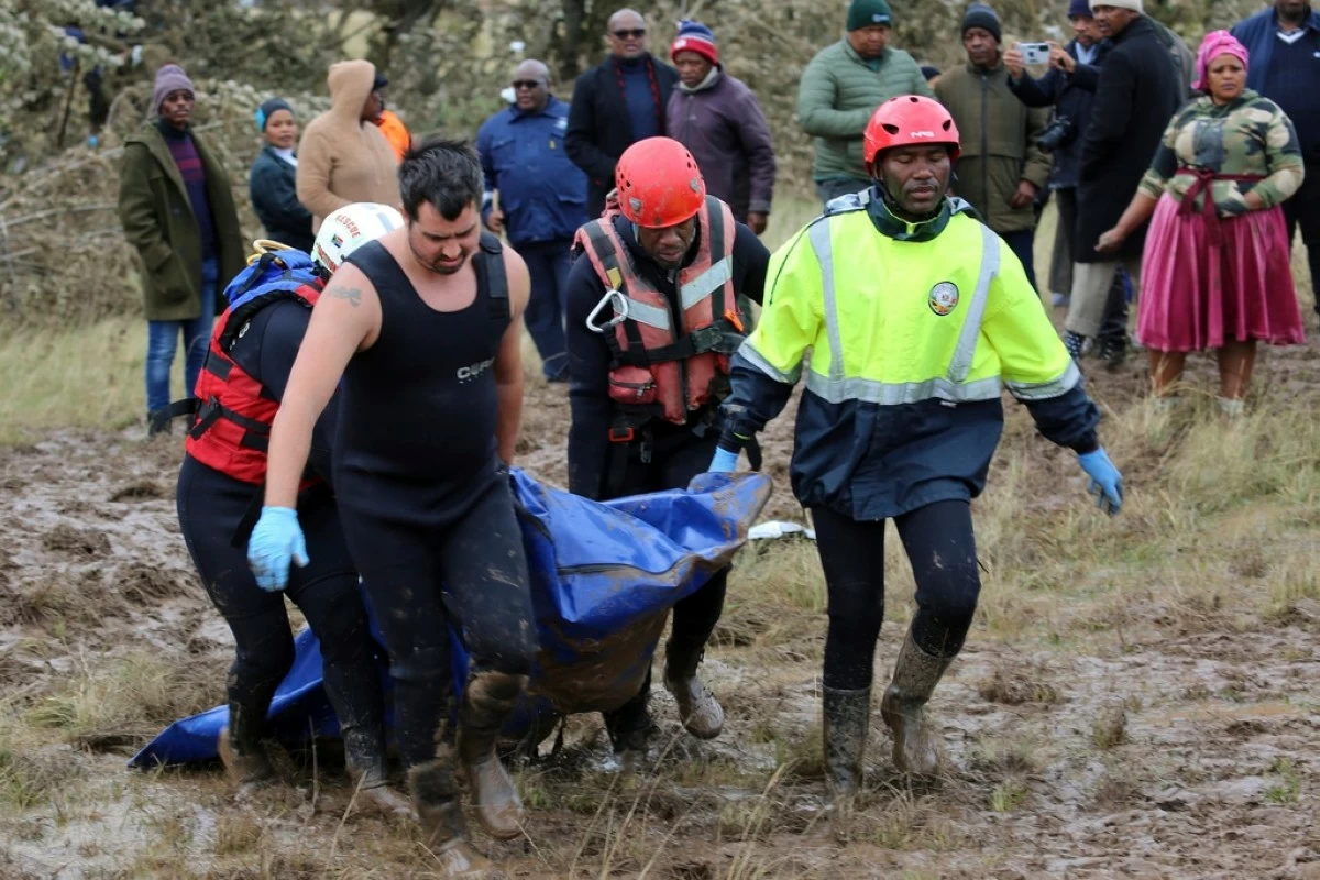 Rescue workers transport a person in a body bag during a rescue operation after floods swept through the area, in Mthatha, South Africa, Wednesday, June 11, 2025. (AP Photo/Hoseya Jubase)