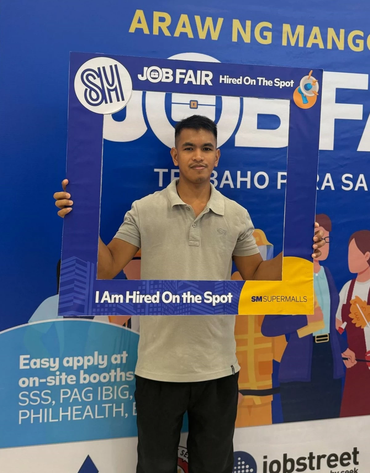 A successful candidate holds a sign indicating he was hired on the spot at SM City Tuguegarao's Job Fair.
