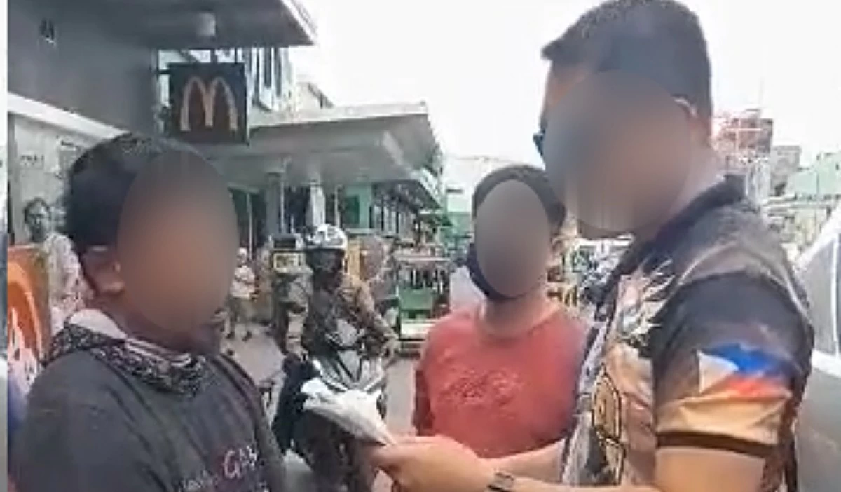 A Taguig police officer with the accused (left) (Photo from Taguig police / SPD)