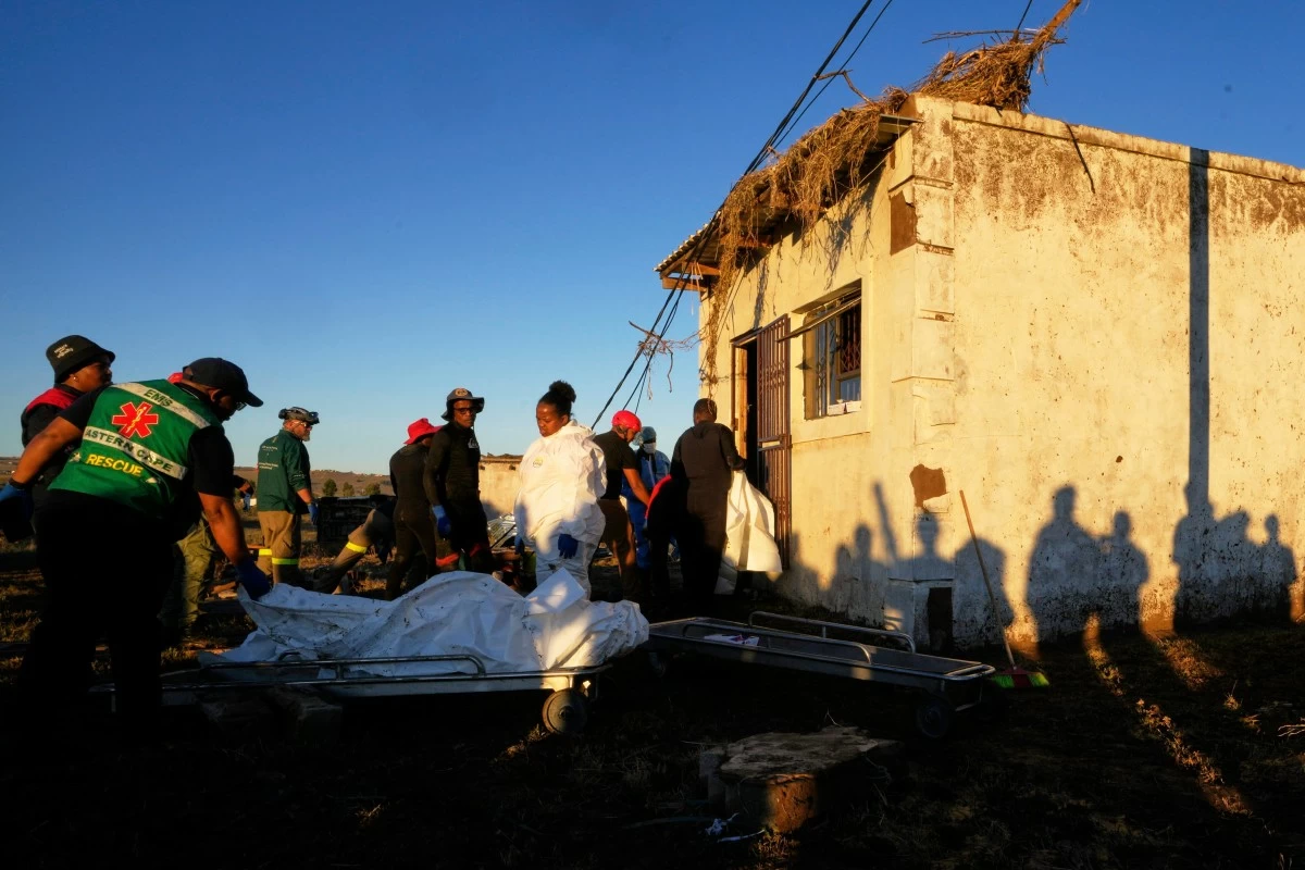 Forensic workers retrieve bodies of a mother and three daughters from inside a one room house after floods swept through the area in Mthatha, South Africa, Thursday, June 12, 2025. (AP Photo/Themba Hadebe)