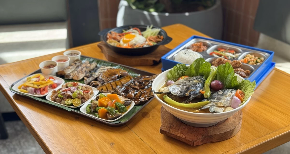 A spread of diverse dishes, including grilled seafood and fresh fish soup from Kain, and a Korean bento box from Seoul Good awaits diners.
