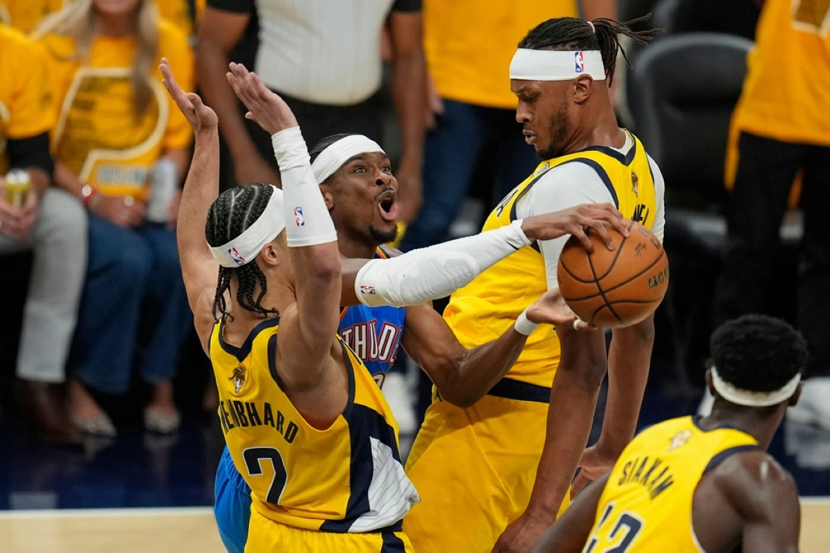 Oklahoma City Thunder guard Shai Gilgeous-Alexander tries to shoot between Indiana Pacers guard Andrew Nembhard (2) and center Myles Turner, right, during the first half of Game 4 of the NBA Finals basketball series, Friday, June 13, 2025, in Indianapolis. (AP Photo/Abbie Parr)