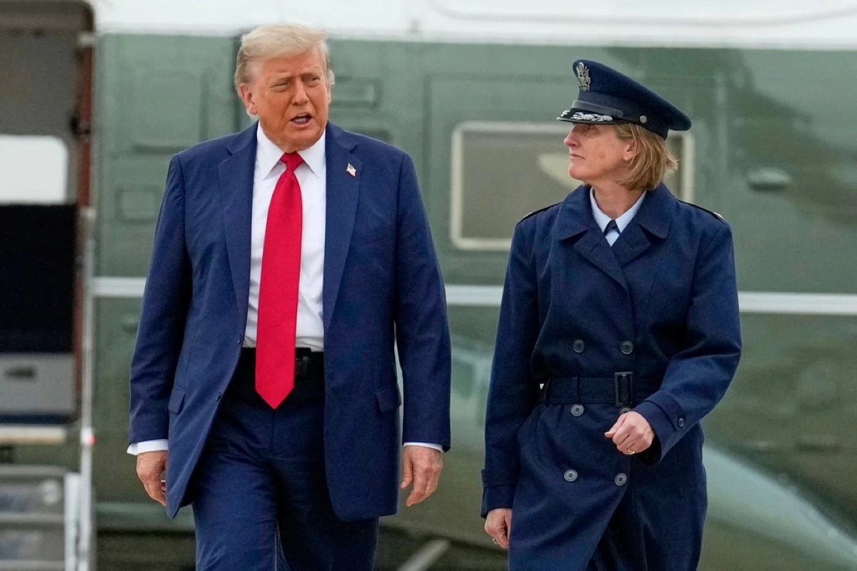 President Donald Trump, left, escorted by Air Force Col. Angela F. Ochoa, Commander, 89th Airlift Wing, walks from Marine One to board Air Force One, Sunday, June 15, 2025, at Joint Base Andrews, Md., for a trip to Canada to attend the G7 Summit. (AP Photo/Mark Schiefelbein)