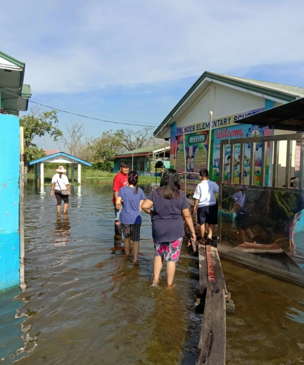 Parents wade in floodwaters as classes open in Bulacan