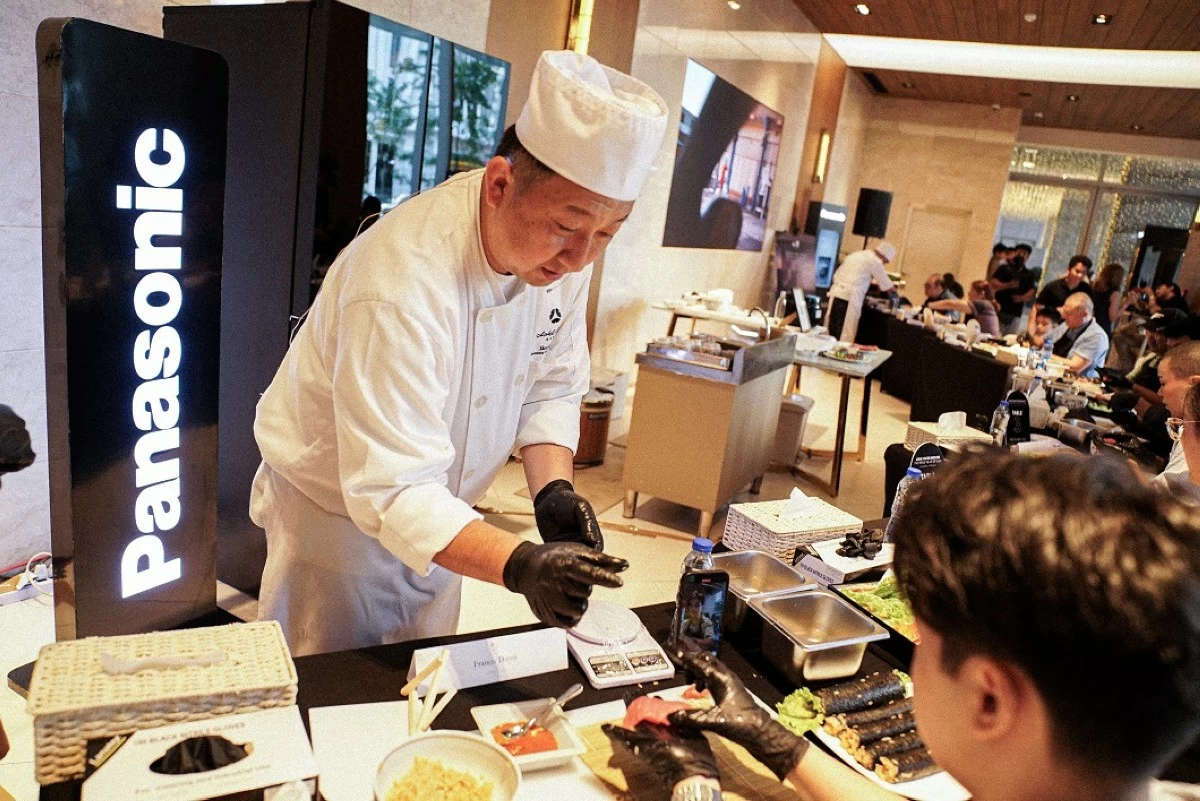 GUIDED BY A MASTER CHEF'S HAND: One of the participants learns the fundamentals of sushi making from renowned Chef Sato of Hotel Okura.