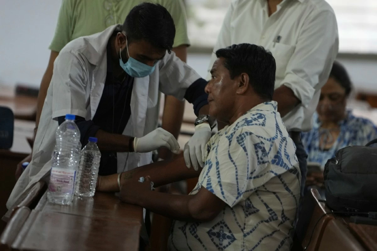 A health worker take DNA sample of a family member of a victim of an airplane that crashed in India's northwestern city of Ahmedabad in Gujarat state, Friday, June 13, 2025. (AP Photo/Ajit Solanki)
