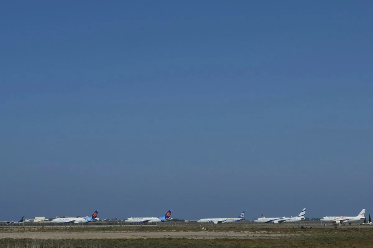 A row of aircrafts belonging to Israeli airlines El Al, Arkia, Israir sit parked in a row along the apron of Cyprus' main airport in Larnaca, Saturday, June 14, 2025. (AP Photo/Petros Karadjias)