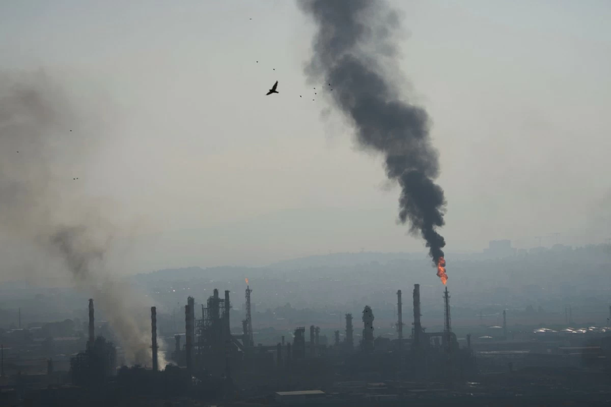 Smoke billows after an Iranian missile struck an oil refinery in Haifa, northern Israel, early Monday, June 16, 2025. (AP Photo/Ariel Schalit)