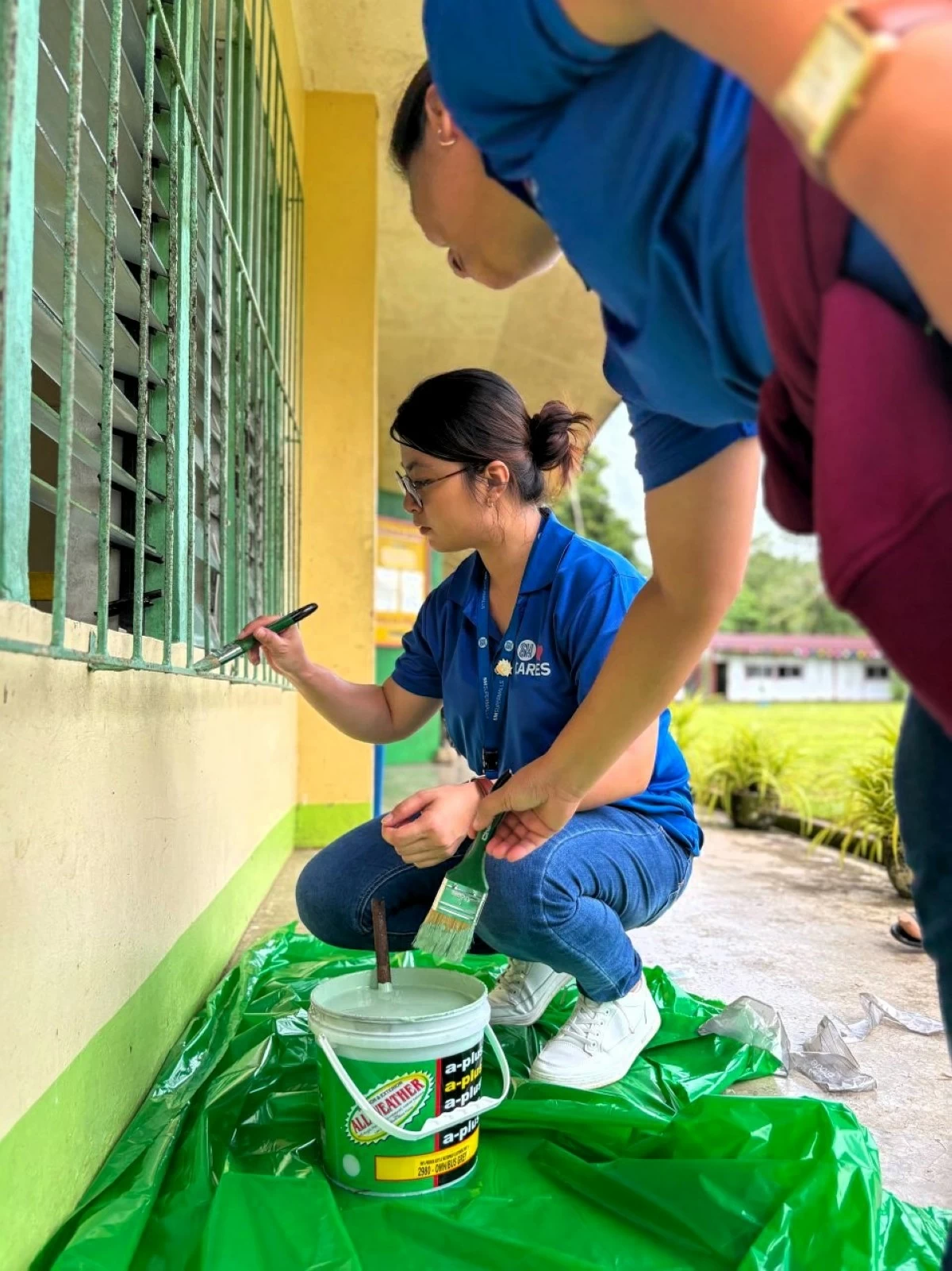 Employee volunteers from SM Center Ormoc paint classrooms as part of Brigada Eskwela, helping create more inspiring learning spaces where students can thrive.