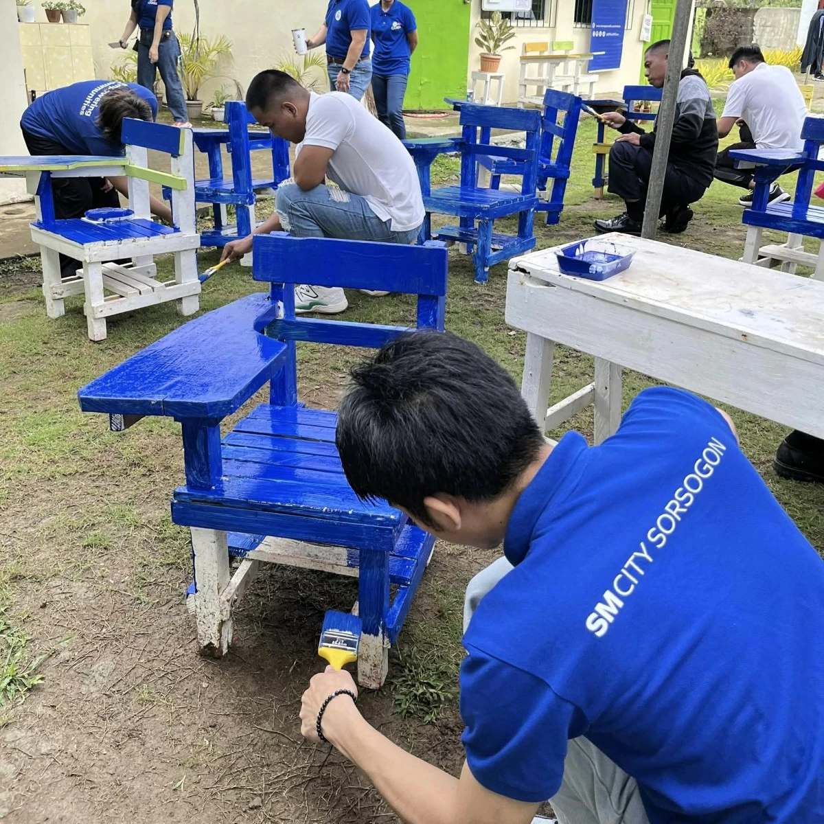 Embodying the spirit of bayanihan, SM City Sorsogon employee volunteers paint school chairs with dedication—bringing new life to classrooms through Brigada Eskwela.