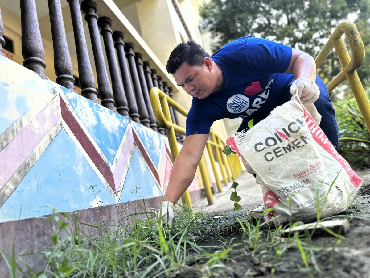 An SM City Mindpro volunteer helps clean the school grounds during Brigada Eskwela—making way for brighter days and better learning.