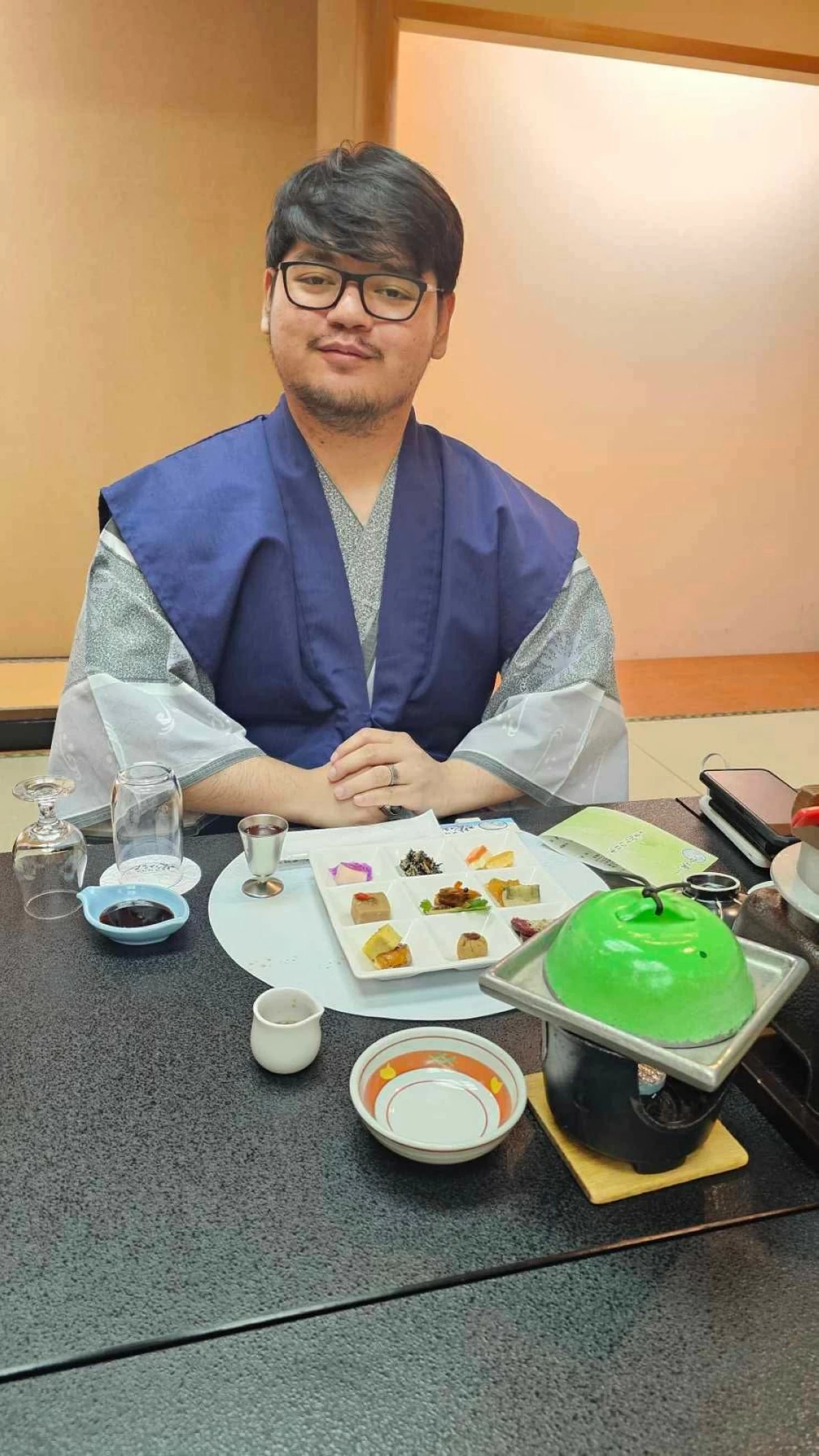 FULLY IMMERSED The author enjoying sushi and drinks while wearing a robe provided by the inn.