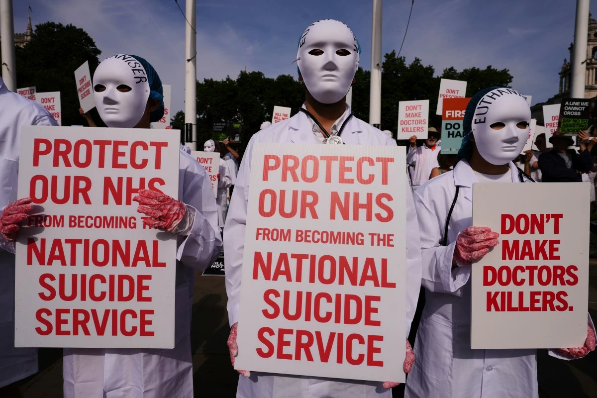 Demonstrators against assisted dying hold banners outside Parliament in London, Friday, June 20, 2025, as British lawmakers are set to vote Friday on whether to back a bill to help terminally ill adults end their lives in England and Wales. (AP Photo/Kirsty Wigglesworth)