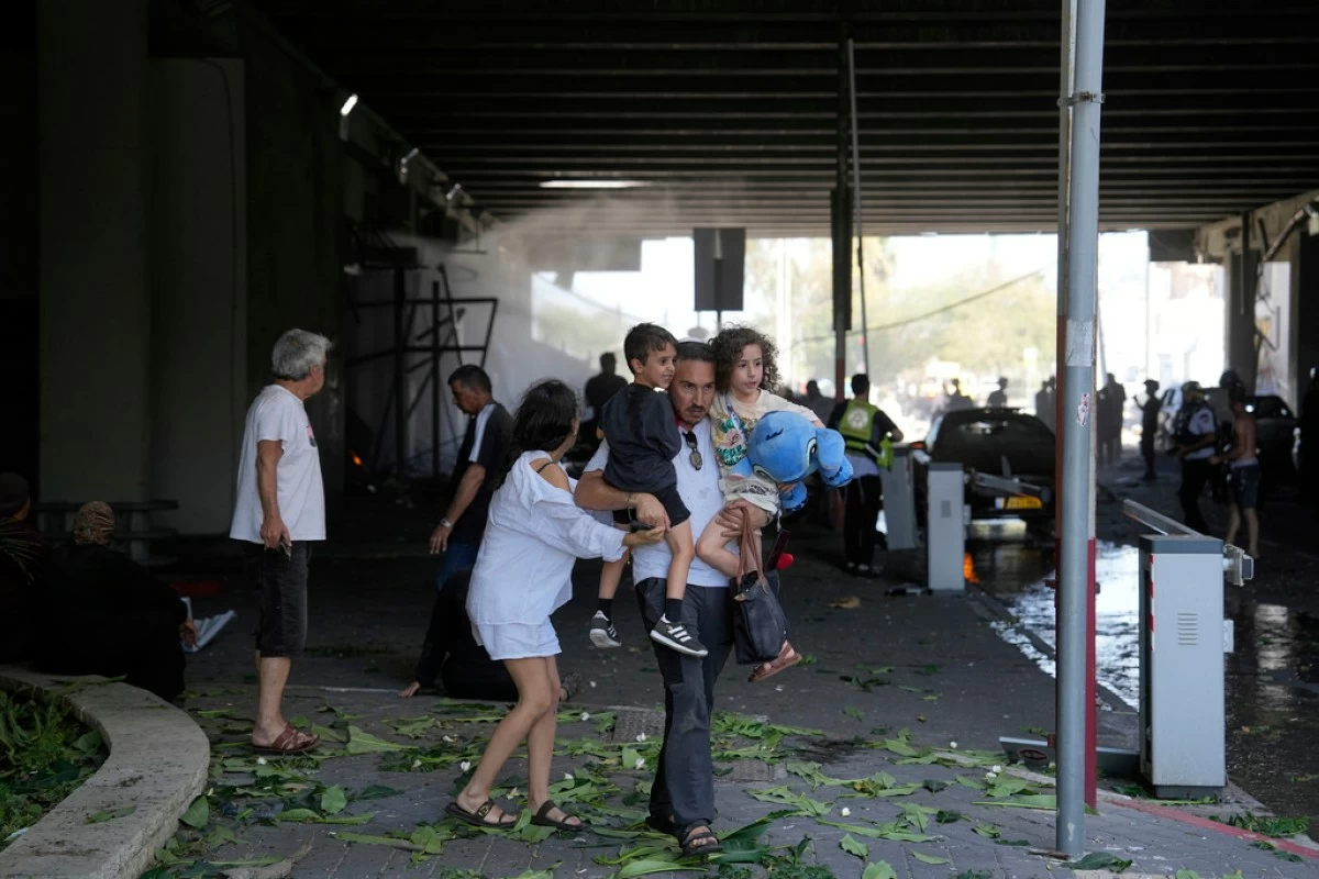 People evacuate after a missile launched from Iran struck in Haifa, Israel, Friday, June 20, 2025. (AP Photo/Baz Ratner)