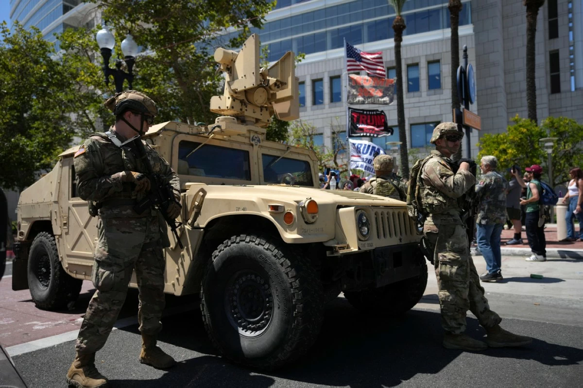 California National Guard stand guard along a street near protesters and Trump supporters in Santa Ana, Calif. on Tuesday, June 10, 2025. (AP Photo Jae C. Hong)