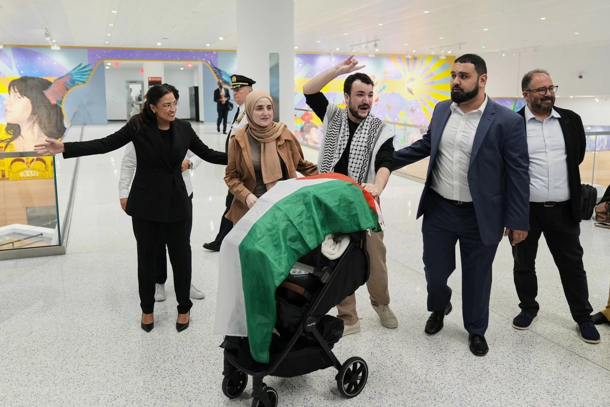 Mahmoud Khalil, center, reacts to supporters alongside his wife, Noor Abdallah, second from left, upon arriving at Newark International Airport, Saturday, June 21, 2025, in Newark, N.J. (AP Photo/Seth Wenig)