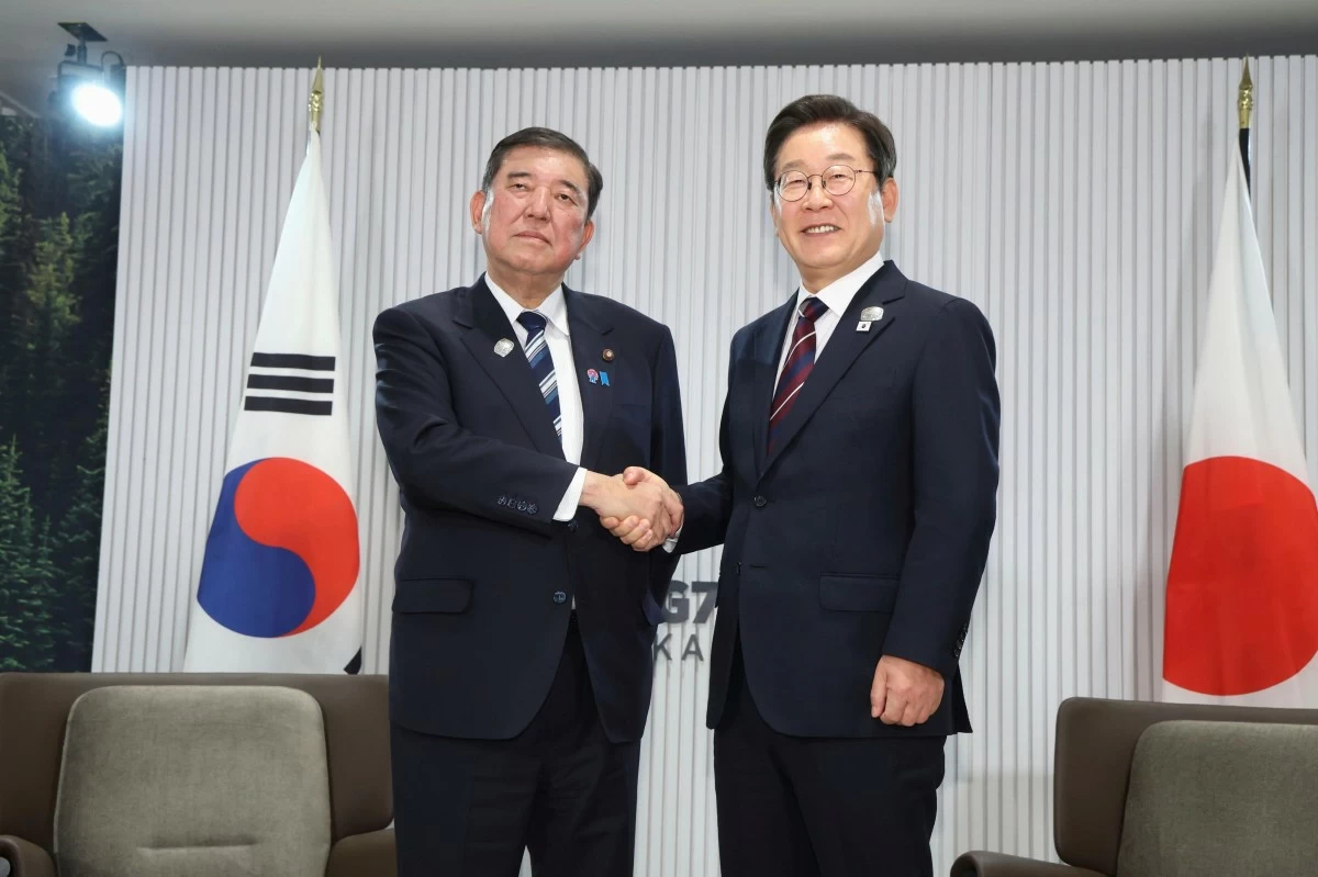Japanese Prime Minister Shigeru Ishiba, left, and South Korean President Lee Jae Myung, right, shake hands ahead of a bilateral meeting on the sidelines of the G7, in Kananaskis, Alberta, on June 17, 2025. (Kyodo News via AP)